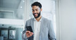 © peopleimages.com - Communication, smile and businessman text with smartphone in office for networking, email and corporate discussion. Male person, mobile message or company social media post for project and consulting