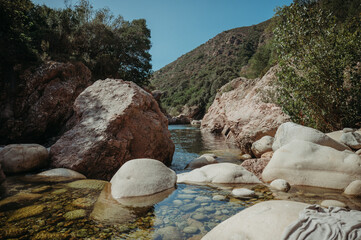 Wall Mural - Round rocks in a river of Corsica on a sunny day
