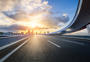 Wall Mural - asphalt highway road and bridge with modern city skyline at sunrise