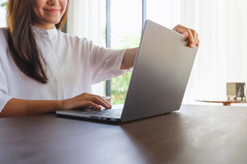 Wall Mural - closeup image of a woman opening or closing laptop computer, getting ready for work