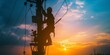 © MiniRiz - silhouette of electrical worker climbs a utility pole during a vibrant sunset. maintaining the power grid with evening sky background