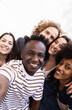 © Xavier Lorenzo - Vertical shot of young group of happy people taking selfie portrait together outdoor. Millennial diverse united best friends student having fun on vacation. Youth community and friendship concept.