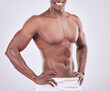 © peopleimages.com - Abdomen, muscle and African man for fitness with towel, exercise and cleaning in studio. Male bodybuilder, strong body and torso with abs for wellness or health and hygiene by white background