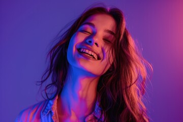 Female fashion model in cotton shirt smiling in neon light.