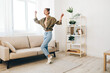 © SHOTPRIME STUDIO - Jumping for Joy: A Happy Woman Dancing and Singing in her Carefree Home