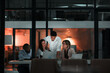 © Reese Coop/peopleimages.com - Teamwork, laptop and business people in office at night with stock market charts for corporate investment. Discussion, computer and financial advisors working on company profit report with deadline.