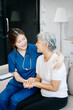© Nuttapong punna - Asian caregiver doctor examine older patient woman therapist nurse at nursing home taking care of senior elderly woman sit on sofa.Medical service concept.