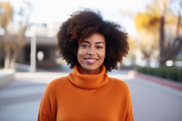 Wall Mural - Portrait of a cheerful afro-american woman in her 40s dressed in a warm wool sweater over modern university campus background