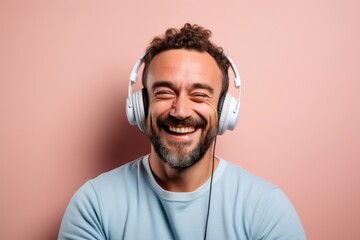 Canvas Print - Portrait of a cheerful man in his 30s sporting a comfortable hoodie and headphones in front of pastel or soft colors background