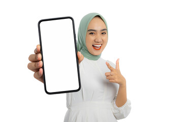 Wall Mural - Excited young Asian woman in green hijab and white blouse showing smartphone with blank screen isolated on white background