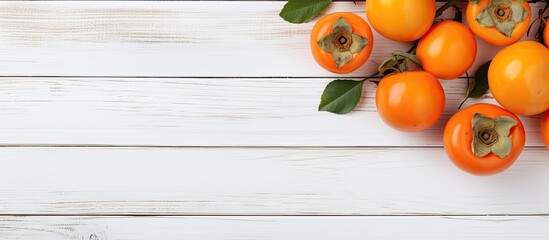 Aufkleber - healthy diet concept Fresh ripe persimmons and tangerines on white wooden background top view flt lay. Creative banner. Copyspace image