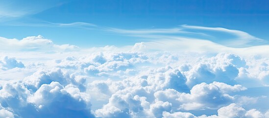 Poster - Wonderful view from the airplane window flying above the clouds Cumulus clouds with blue sky in sunny day and soft sunlight in the afternoon Nature background. Creative banner. Copyspace image
