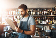 © DoneDeal/peopleimages.com - Barman, writing and clipboard for restaurant management with stock, inventory or check for liquor. Man, bartender and checklist with thinking, order or inspection for alcohol, invoice or notes at pub