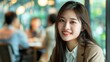 © Denisa - Asian Young woman smiling at camera in a cafe