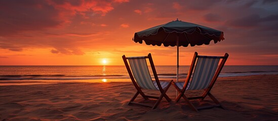 Poster - two beach chairs with folding umbrella on the beach in sunset time. Creative banner. Copyspace image