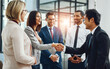 © Seisa/peopleimages.com - Group, business people and shaking hands for welcome, introduction or meeting in office. Handshake, smile and team with deal for collaboration, agreement or thank you for b2b partnership opportunity