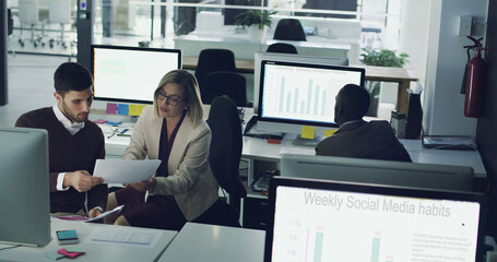 Poster - Business people, teamwork and reading paperwork in office with computer for social media project and task for company. Corporate, employees and working late for online, research and statistics.