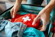 © ActionGP - Close-up of a person packing a first aid kit into a travel bag for safety, health, and preparedness. Generated AI