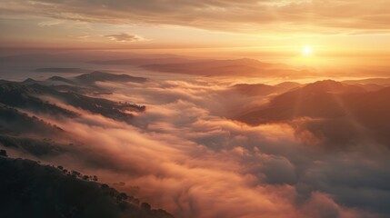 Wall Mural - Scenic view of fog covered valley with mountains and hills at sunset