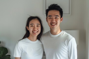 Poster - Portrait of a content asian couple in their 20s showing off a lightweight base layer isolated in bare monochromatic room