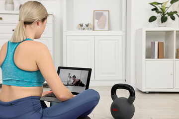 Poster - Online fitness trainer. Woman watching tutorial on laptop at home