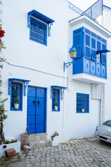 Traditional blue Tunisian metal door with a pattern in a white building in the city of Sidi Bou Said in Tunisia in the summer on a sunny day