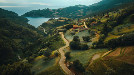 Wall Mural - Aerial shot of a picturesque village road winding through hills