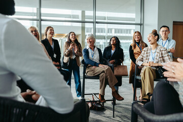 Wall Mural - diverse group of colleagues laughing during an office meeting in a modern workspace