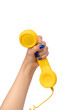 © Nikolay - Yellow handset in woman hand isolated on white. Copy space.