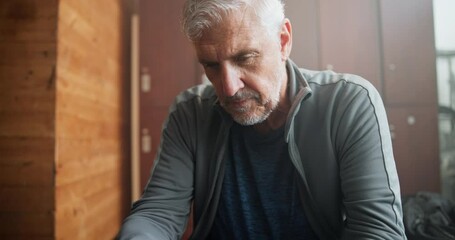 Gym, phone and man with thinking in locker room for fitness, communication or workout progress. Training, network and senior person with technology for exercise idea, search or tracking of health app