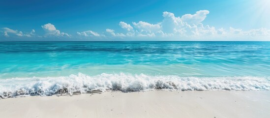 Sticker - Engaging and natural setting: White sandy beach on a sunny summer day with turquoise ocean water and blue sky background; ideal for a summer vacation with room for text.