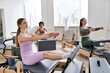 © LIGHTFIELD STUDIOS - Diverse group of women engaging in a Pilates class, focusing on core strength and flexibility.