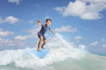 Wall Mural - Full length portrait of a boy riding a surfboard