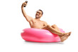 © Ljupco Smokovski - Man sitting on a swimming ring and taking a selfie with a smartphone