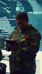 Poster - Vertical Video Female military officer supervising radar surveillance footage to input and process tactical data on a big screen. Woman uses global reconnaissance in creating battlefield maps. Camera
