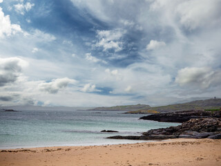 Wall Mural - Yellow sandy beach and tropical blue ocean water and stunning cloudy sky. West coast of Ireland. Irish landscape scene. Nobody. Travel and tourism. Calm and peaceful coastline.