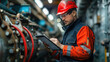 © khonkangrua - An engineer in a hard hat and safety gear, examining plans in an industrial plant, showcasing industrial work.