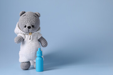 Canvas Print - Toy bear and nasal spray on light blue background, space for text