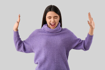 Wall Mural - Scared young woman on grey background