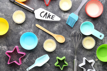 Wall Mural - Composition with muffin baking cups and utensils on grunge background