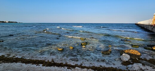 Wall Mural - The Caribbean sea in the morning. Rocky shore. Pier at the side.