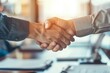 © CHONCHANOK PHOTO - Two businessmen shaking hands in agreement, signifying a successful deal or partnership.