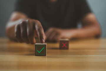 Poster - businessman's hand chooses the one wooden cube block with the green right for approve and reject bus