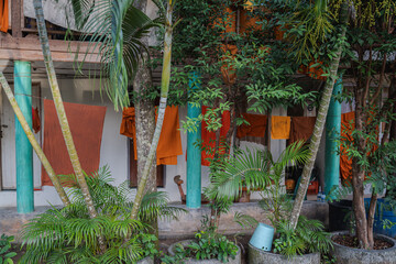 Naklejka na meble Traditional Thai Monastery with Drying Robes and Lush Plants