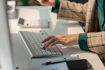 working in workplace on the desk with computer, female employee is looking on document, en entrepreneur is trying so hard to build startup company, finance department