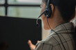 © PhotosD - an Asian female works as call center support, this employee as telemarketing is giving an advice to customer, she is wearing headset to talk to client and help them via helpline
