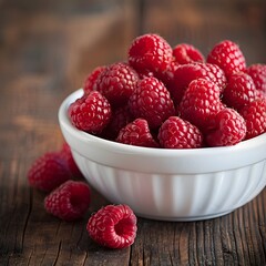 Wall Mural - Close up of fresh ripe red raspberries in a white bowl on rustic wooden table with copy space