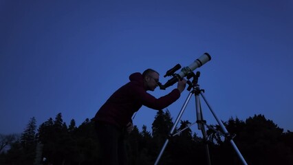 Wall Mural - amateur astronomer looking at the evening skies, observing planets, stars, moon and other celestial 