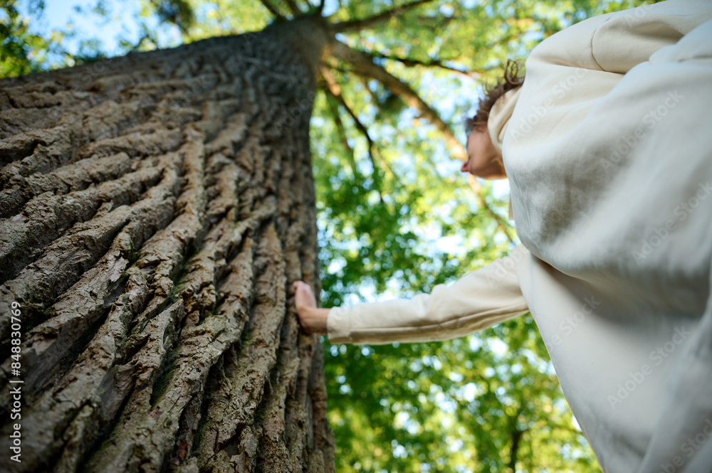 Pretty woman leaning on the old tree. Female hugging huge tree trunk ...