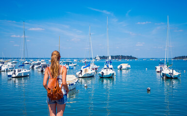 Rear view of female looking at boats in the sea